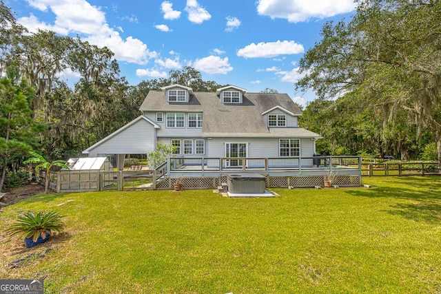 back of house featuring a wooden deck, a greenhouse, an outbuilding, fence, and a yard