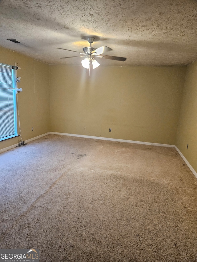 unfurnished room featuring a textured ceiling, ceiling fan, and carpet floors