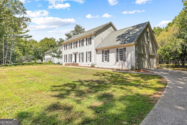 exterior space featuring driveway, a garage, and a yard