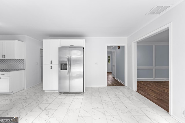 kitchen with marble finish floor, stainless steel refrigerator with ice dispenser, visible vents, and white cabinetry