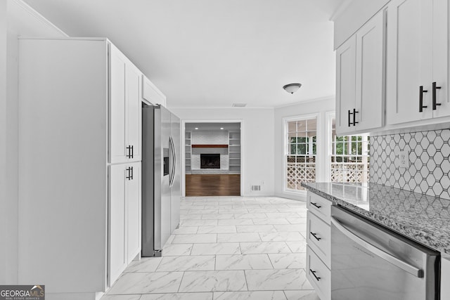 kitchen featuring appliances with stainless steel finishes, white cabinetry, and light stone countertops