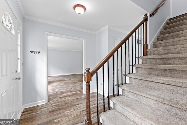 entryway with ornamental molding, stairway, baseboards, and wood finished floors