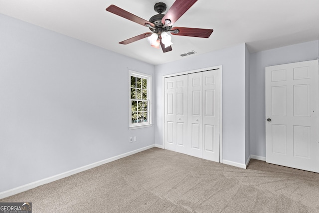 unfurnished bedroom featuring a closet, baseboards, visible vents, and carpet flooring