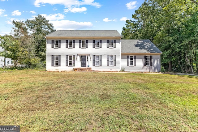 colonial home with a shingled roof, crawl space, and a front lawn