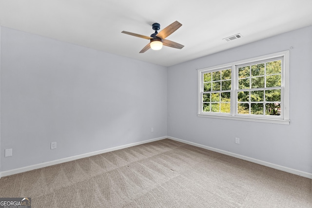 unfurnished room featuring baseboards, ceiling fan, visible vents, and light colored carpet