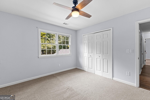 unfurnished bedroom with visible vents, baseboards, ceiling fan, carpet, and a closet