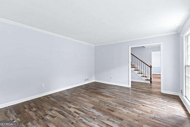 spare room with baseboards, crown molding, visible vents, and dark wood-style flooring