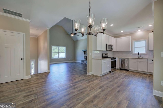 kitchen featuring visible vents, a sink, stainless steel appliances, crown molding, and open floor plan