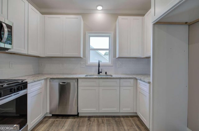 kitchen with stainless steel appliances, light stone counters, sink, decorative backsplash, and dark hardwood / wood-style floors