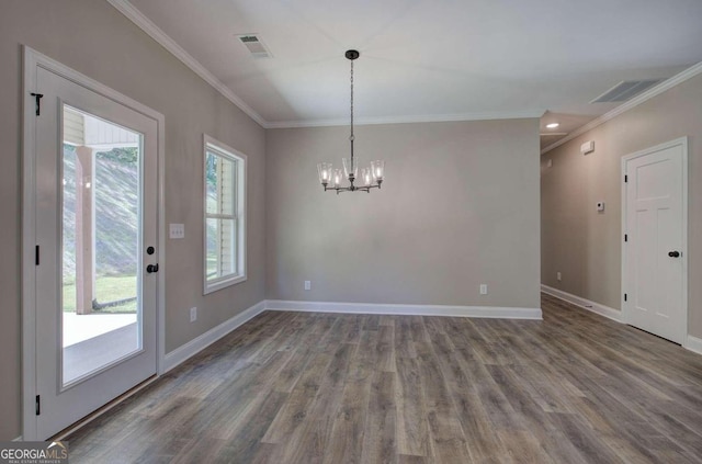 unfurnished dining area with crown molding, hardwood / wood-style flooring, a notable chandelier, and a wealth of natural light