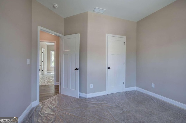 unfurnished bedroom with visible vents, carpet, and baseboards