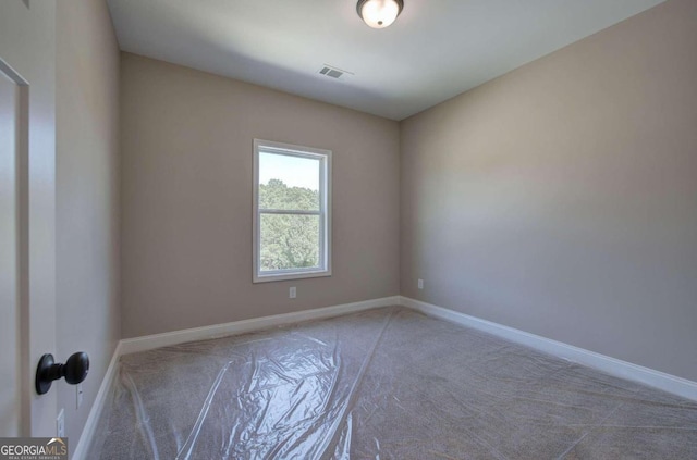 carpeted spare room featuring visible vents and baseboards