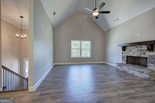 unfurnished living room with ceiling fan with notable chandelier, high vaulted ceiling, hardwood / wood-style floors, and a stone fireplace