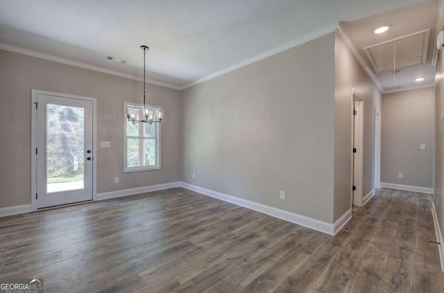 unfurnished dining area featuring visible vents, baseboards, dark wood finished floors, attic access, and ornamental molding