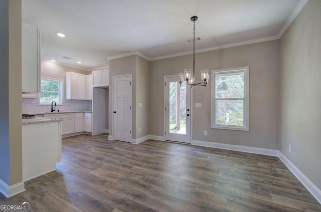 kitchen featuring decorative light fixtures, dark wood-type flooring, decorative backsplash, a chandelier, and white cabinets