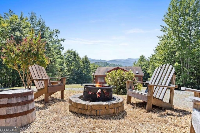 view of yard with a mountain view and an outdoor fire pit