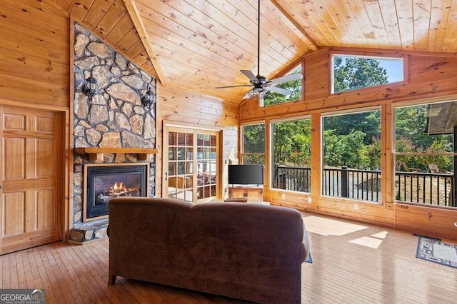 living room with wood walls, wood-type flooring, a fireplace, and wooden ceiling