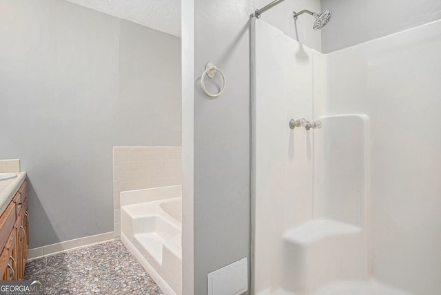 bathroom featuring plus walk in shower, tile patterned floors, a textured ceiling, and vanity