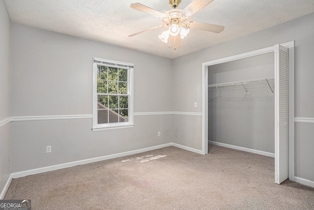 unfurnished bedroom featuring carpet, a textured ceiling, ceiling fan, and a closet