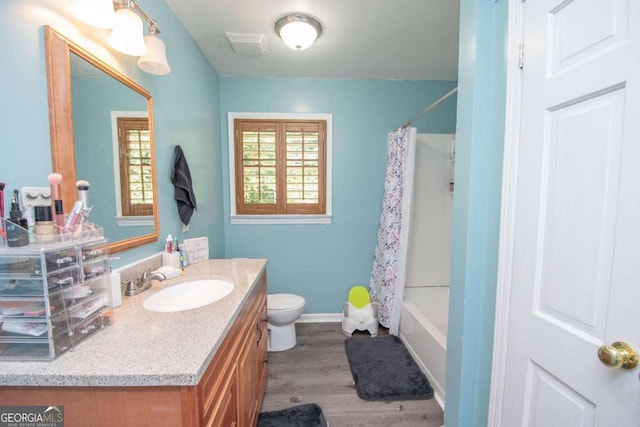 full bathroom with vanity, toilet, hardwood / wood-style floors, and shower / bath combination with curtain