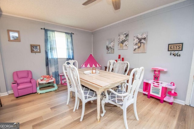 dining space with ceiling fan, crown molding, and light hardwood / wood-style flooring