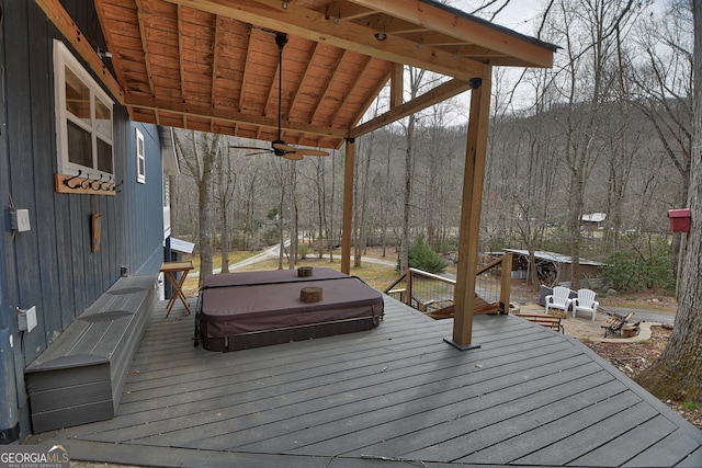 deck featuring ceiling fan and a covered hot tub