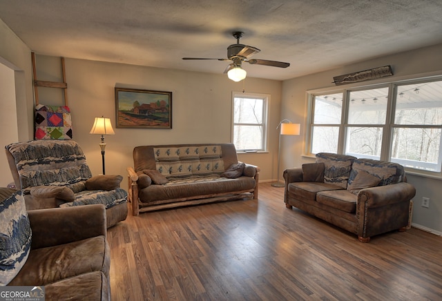 living room featuring dark wood-type flooring, plenty of natural light, and ceiling fan