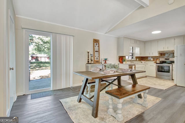 kitchen featuring stainless steel electric range, white cabinets, light wood-type flooring, vaulted ceiling with beams, and white fridge