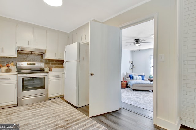 kitchen with ventilation hood, stainless steel range with electric cooktop, white refrigerator, white cabinetry, and light hardwood / wood-style floors