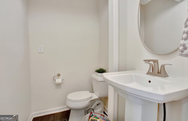 bathroom featuring sink, hardwood / wood-style floors, and toilet