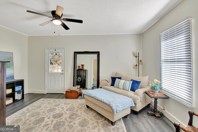 interior space featuring ornamental molding, hardwood / wood-style floors, a textured ceiling, and ceiling fan