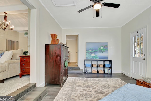 bedroom featuring ornamental molding, dark wood-type flooring, and ceiling fan with notable chandelier