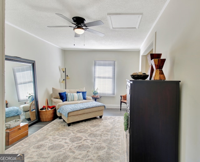 bedroom with ceiling fan, hardwood / wood-style flooring, and a textured ceiling