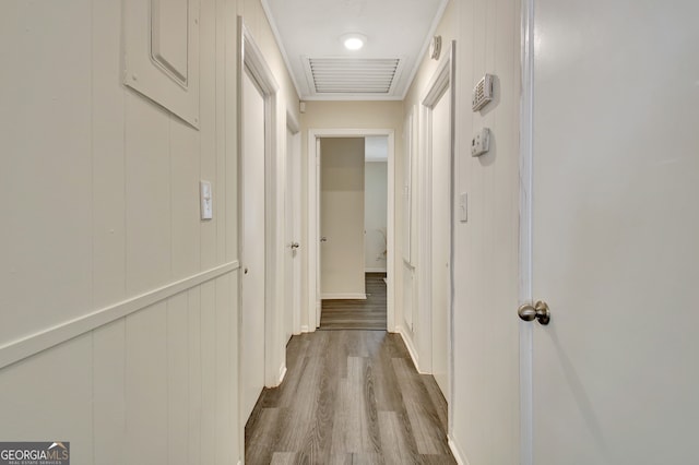 hallway with light hardwood / wood-style floors and wood walls