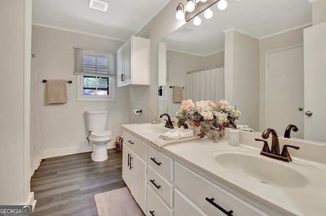 bathroom featuring toilet, hardwood / wood-style floors, vanity, and ornamental molding