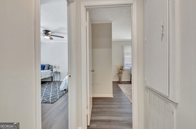 hallway with light hardwood / wood-style floors and a textured ceiling