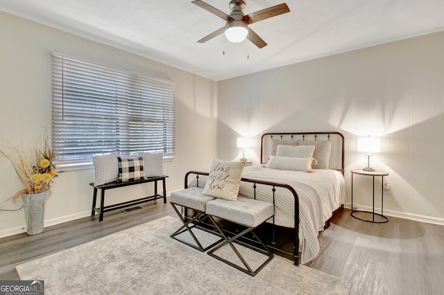 bedroom with crown molding, hardwood / wood-style flooring, and ceiling fan