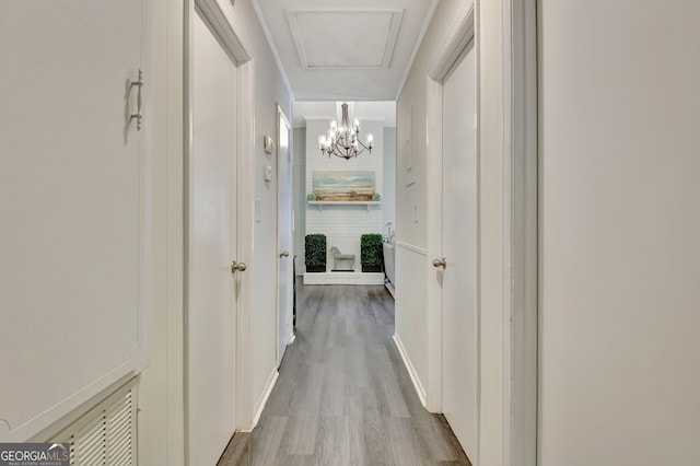 hallway with a chandelier and hardwood / wood-style floors