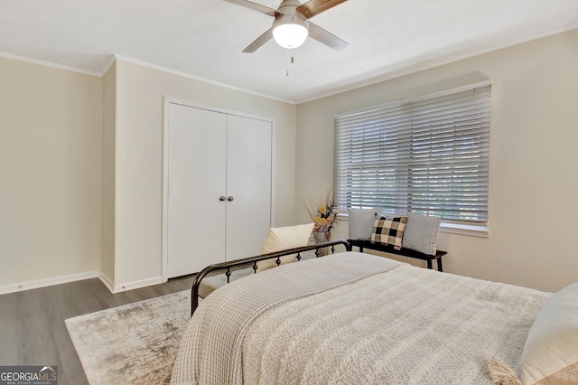 bedroom with ornamental molding, dark hardwood / wood-style floors, a closet, and ceiling fan