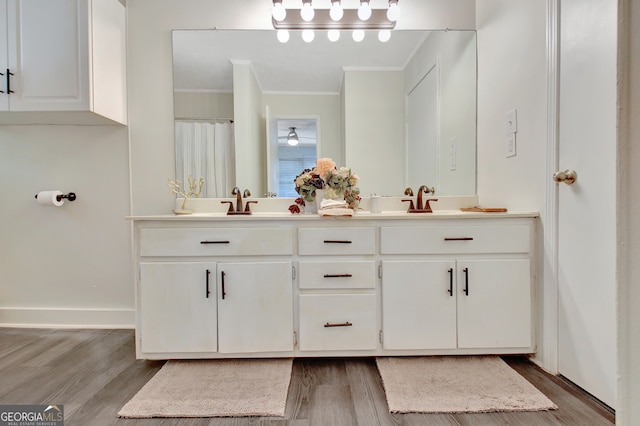 bathroom with vanity, ornamental molding, and hardwood / wood-style flooring