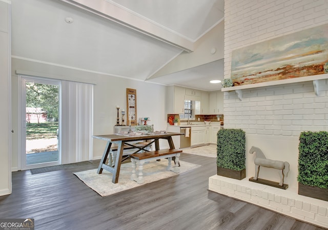 dining space with light hardwood / wood-style flooring, sink, crown molding, and vaulted ceiling