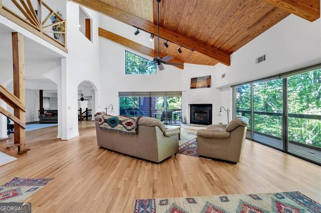 living room with beamed ceiling, wooden ceiling, high vaulted ceiling, hardwood / wood-style flooring, and ceiling fan