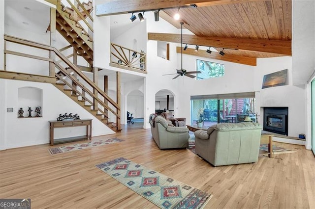 living room featuring beamed ceiling, high vaulted ceiling, light hardwood / wood-style flooring, ceiling fan, and wooden ceiling