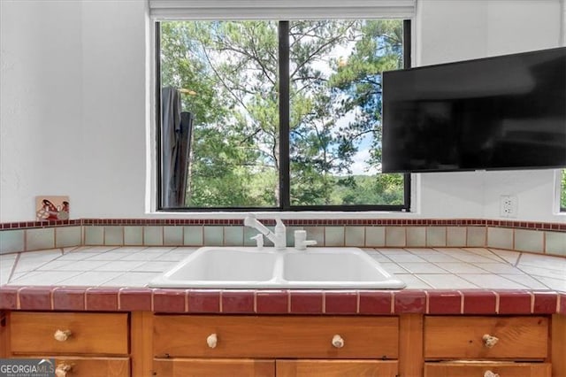 kitchen featuring tile countertops, a wealth of natural light, and sink