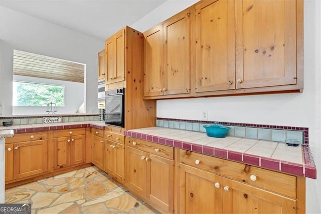 kitchen featuring oven and tile countertops