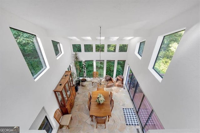 living room featuring a wealth of natural light, a high end fireplace, and a towering ceiling