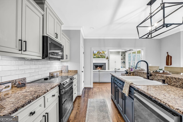 kitchen featuring dishwasher, hanging light fixtures, dark wood-type flooring, electric range, and sink