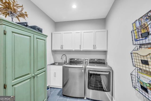 laundry room featuring tile patterned floors, washing machine and dryer, cabinets, and sink