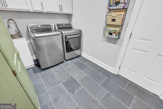 clothes washing area with cabinets, dark tile patterned floors, independent washer and dryer, and sink