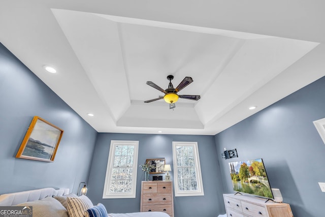 bedroom with a tray ceiling and ceiling fan